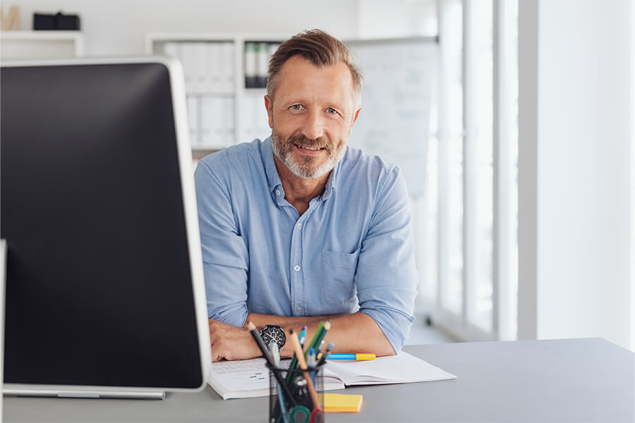 Smiling middle-aged man working at his desk 