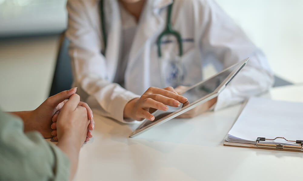 Doctor showing tablet to patient