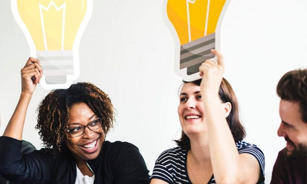 Group of colleagues with lightbulb cards above their heads