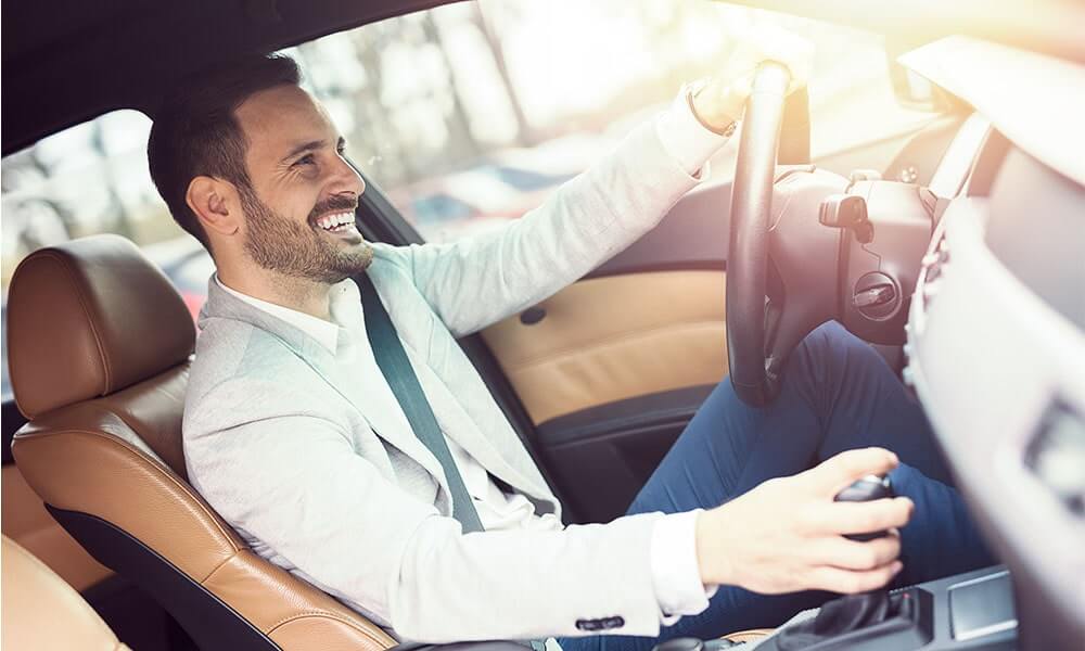 Photo of a man smiling while driving