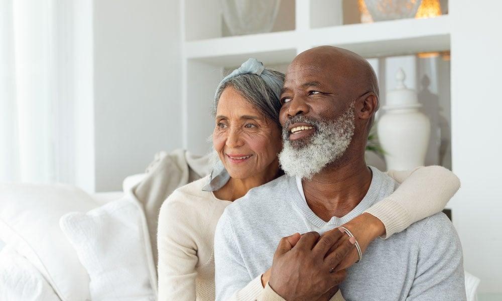 Elderly couple smiling whilst sat down