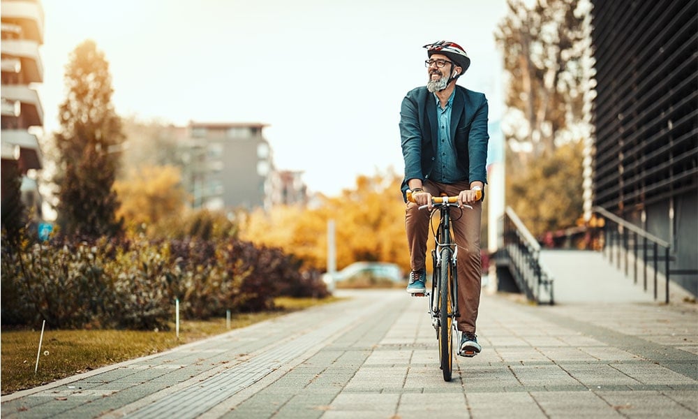 Man cycling to work and smiling